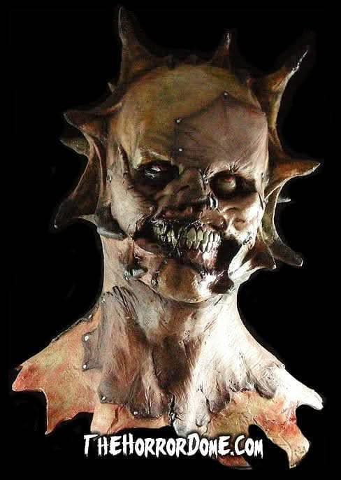 Flesh Ripper Demon Halloween Mask from The Horror Dome. Hyper-realistic hand-painted demon disguise featuring spiky skull, rolled-back eyes, ferocious teeth. Patchwork of skin tones ripped from victims. Durable construction for seamless look over costumes. Perfect for embodying demonic evil at twisted haunted events.